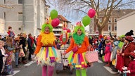 Zu sehen sind zwei weibliche Clowns vor einem Bollerwagen.