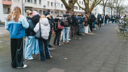 Das Bild zeigt Studierende in einer Schlange vor einer Bibliothek der Universität Köln.