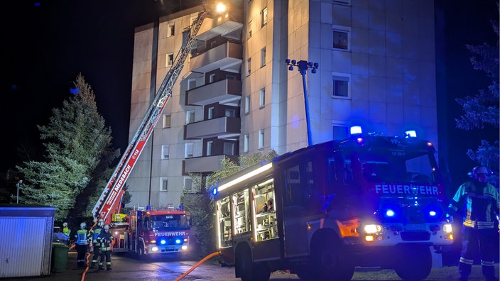 Feuerwehrautos stehen mit eingeschlateten Blaulicht vor einem Mehrfamilienhaus in Medebach.