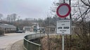 Im Vordergrund ein Straßenschild mit dem Hinweis "Versorgungsdienst und Autos und Busse bis Hotel frei", im Hintergrund eine Straße.