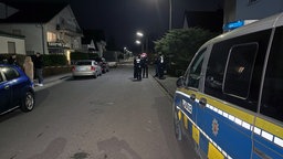 Polizeiwagen und Einsatzkräfte in Wohngebiet bei Nacht.