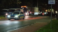 Einsatzfahrzeuge der Polizei mit Castortransport im Hintergrund