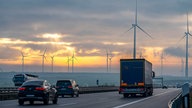 Autos und LKW auf der A44 mit Tagebau und Windrädern im Hintergrund