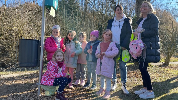 Kinder und Betreuerinnen des Flora Kindergartens mit der neuen Spielplatz-Toilette