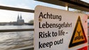 Ein Schild mit "Achtung Lebensgefahr!" hängt am Geländer einer Brücke