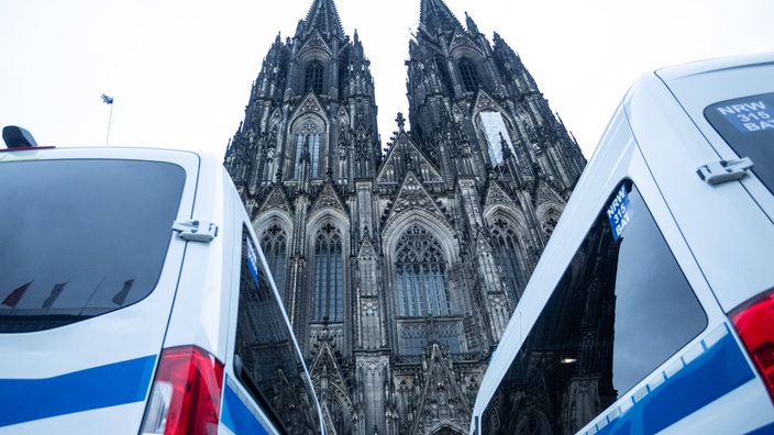 Polizeiautos stehen vor dem Kölner Dom. 