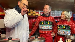 Ein Weinkontrolleur des Landes WDR ist an einem Weihnachtsstand und riecht an einem Wein