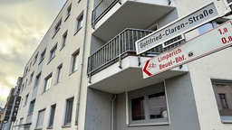 Ein cremefarbenes Mehrfamilienhaus mit 4 Stockwerken und jeweiligen Eckbalkonen