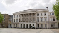 Das Krefelder Rathaus, darüber ein bewölkter Himmel