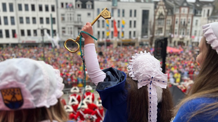 Zu sehen ist die Wäscherprinzessin, wie sie den eroberten Schlüssel der Menge zeigt.