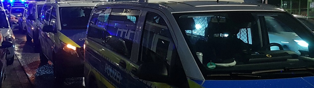 Zu sehen sind mehrere Polizeiwägen in der Dunkelheit.