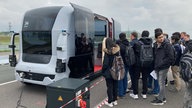 Personen steigen in ein voll automatiesiertes Fahrzeug