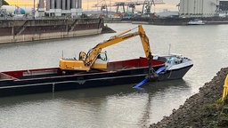 Ein Schiff holt einen Gegenstand aus dem Wasser