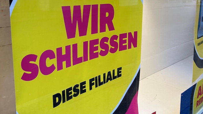 Ein Schild mit der Aufschrift: Wir schliessen diese Filiale.