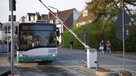 Ein Schulbus fährt an eine Schrank heran, die gerade aufgeht.