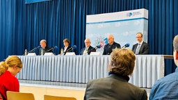 An einem langen Tisch sitzen 5 Menschen bei einer Pressekonferenz mit OB Reker, Polizei  und Domverwaltung 