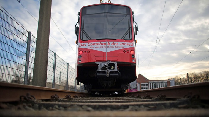 Rote Straßebahn fährt auf den Gleisen