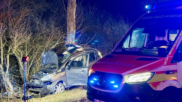 Autowrack neben einem Rettungswagen