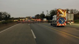 Eine Autobahn-Strecke mit Sperrbaken und einem Fahrzeug