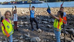 Kinder sammeln Müll an Flussufern