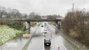 Autos fahren über die überschwemmte Brinkstraße unter einer Brücke durch