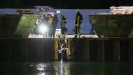 Taucher im Dortmunder Hafenbecken, Feuerwehr überwacht den Einsatz. 