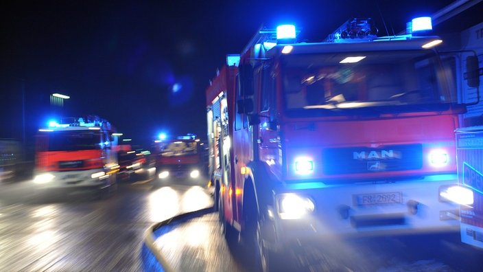 Feuerwehrfahrzeuge bei Nacht mit Blaulicht (Symbolbild)