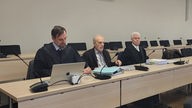 Arzt Dr. Johann Spittler mit seinen Anwälten beim Prozessauftakt zu Sterbehilfe am Essener Landgericht am 12.12.2023