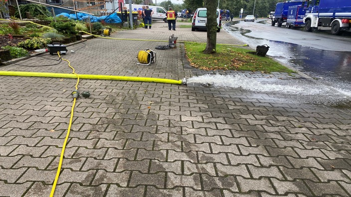 Glebe Schläuche pumpen Wasser aus Häusrn auf die Straße