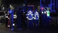 Polizei und Feuerwehr stehen am Tatort zusammen