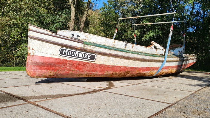 Ein altes Schiff liegt auf Stahlbalken