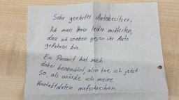 Ein Zettel von einem Parkrempler an einen Autobesitzer