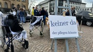 "Keiner da, der pflegen könnte" steht auf einem Schild, mit dem Pflegekräfte auf ihre Situation hinweisen