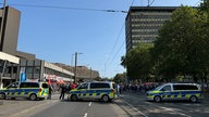 Beschäftige von Thyssenkrupp haben sich in Duisburg versammelt. Im Vordergrund sind mehrere Einsatzwagen der Polizei zu sehen.