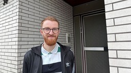 Urenkel Marius Bause steht vor dem Hauseingang, wo sein Urgroßvater bis zu seiner Verhaftung gewohnt hat.