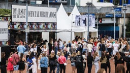 Fans stehen in der Schlange vor dem Merchandise-Shop