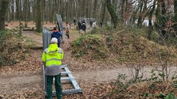 Viele Helfer tragen Zäune durch den Wildpark Weeze