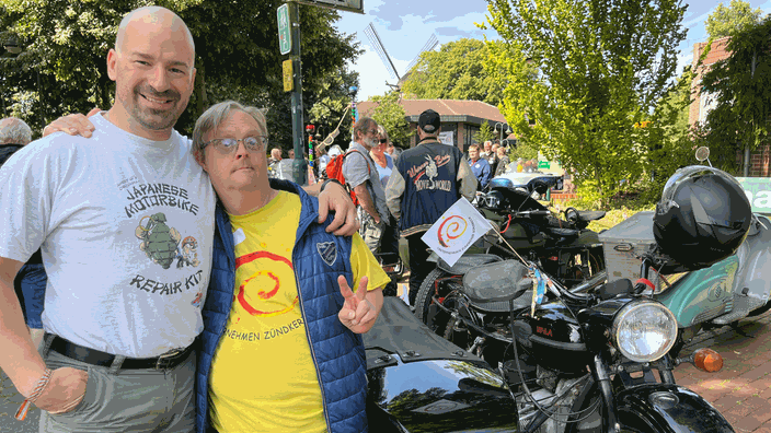 Zwei Männer posen vor einem Motorrad