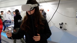 Eine Schülerin aus Duisburg trägt im Wissenschaftstruck eine VR-Brille.