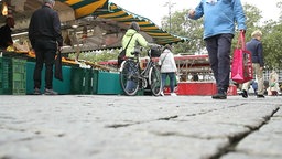 Passanten an den Ständen auf dem Wochenmarkt