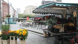 Ein Stand mit Blumen, im Hintergrund weitere Verkaufs- und Imbissstände