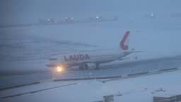 Flughafen Köln-Bonn im Schnee; ein Flugzeug rollt im Schneegstöber über die Rollbahn