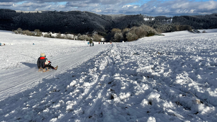 Rodeln im Schnee in der Eifel bei Kaltenborn