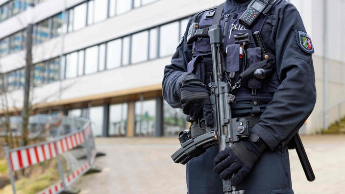 Schwer bewaffnete Polizei steht vor der Schule