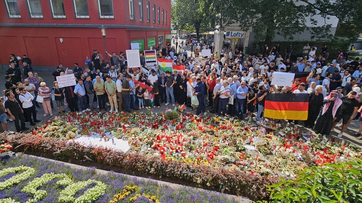 Blumen werden niedergelegt, kurdische, aber auch palästinensischen Fahnen gezeigt.