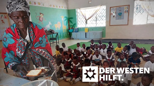 Eine Frau verteilt Essen in einem Klassenzimmer