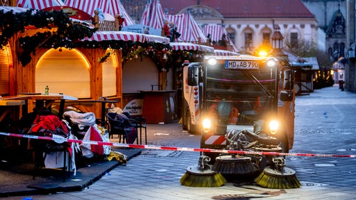 Straßenkehrmaschine fährt über den Magdeburger Weihnachtsmarkt