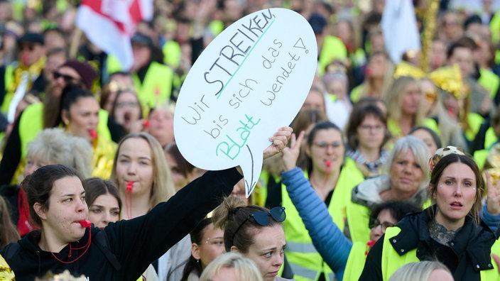 Streikende Frauen in Warnwesten mit Schild