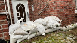 Sandsäcke liegen zum Schutz vor einem Unwetter vor einem Haus