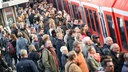 Fahrgäste steigen auf einem überfüllten Bahnsteig in eine Bahn ein